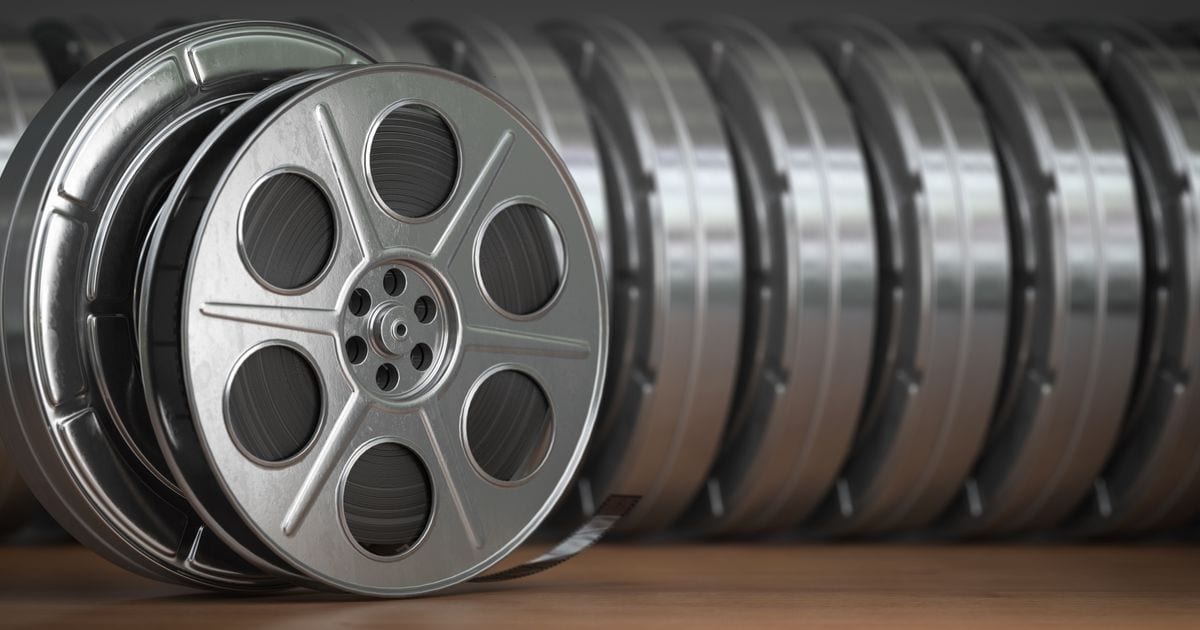 A row of silver film reels standing on edge, one in front of the others