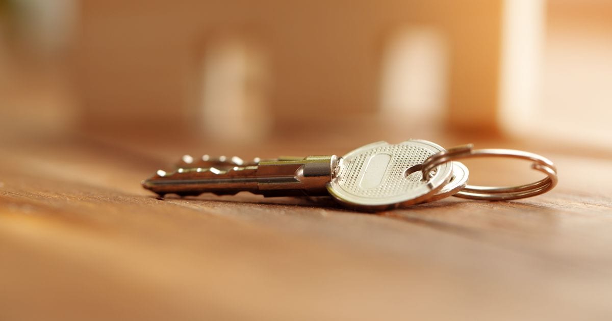 A set of keys on a ring lying on a wooden surface