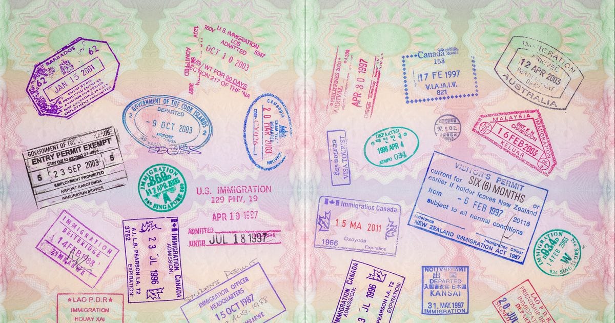 Two passport pages covered in overlapping immigration stamps